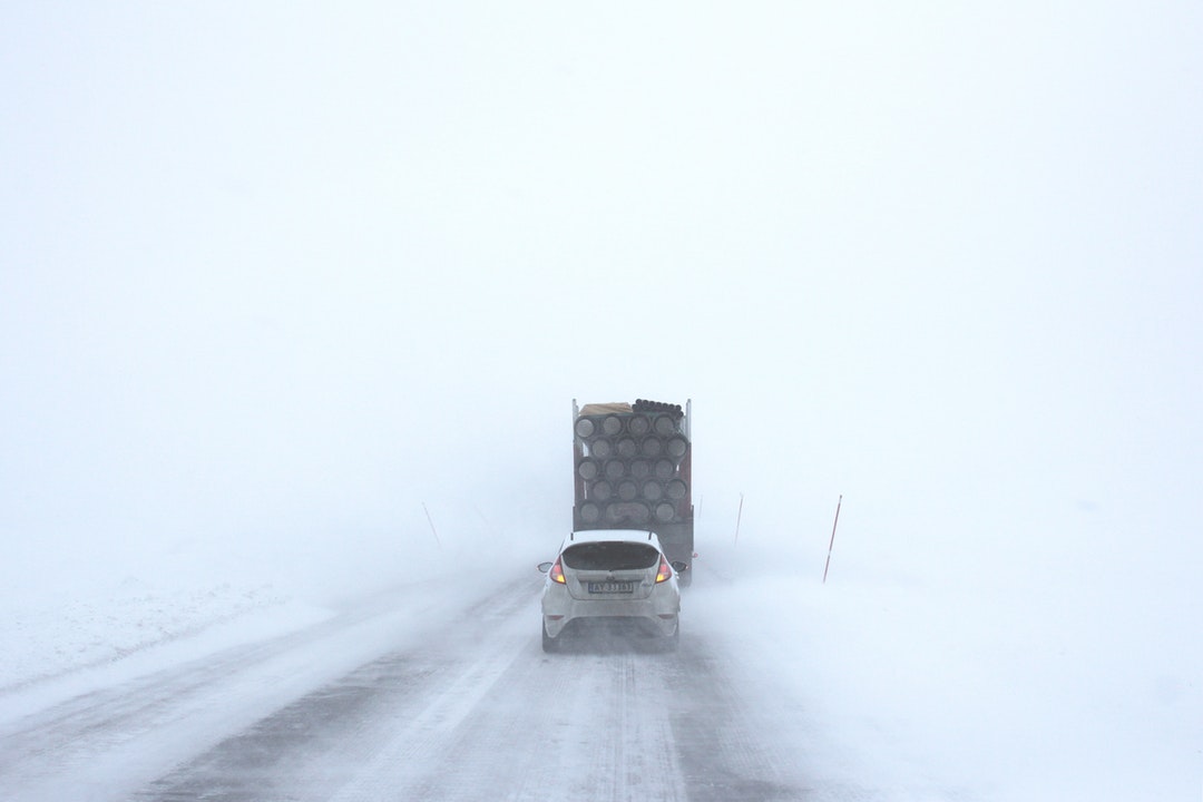 car and truck driving in snow