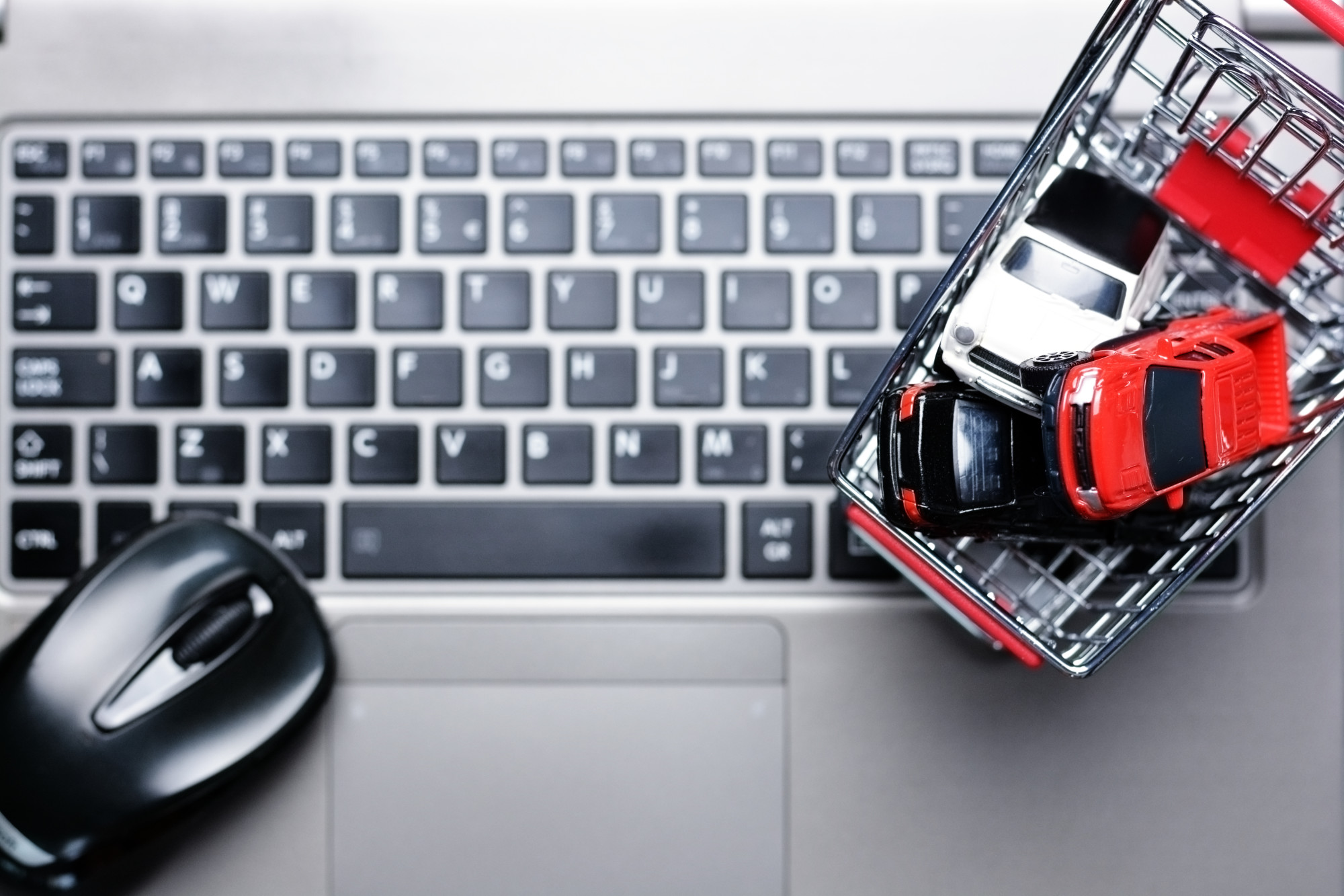 shopping cart with cars on computer keyboard